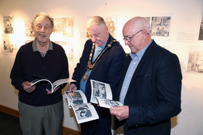 Mayor of Causeway Coast and Glens, Councillor Steven Callaghan alongside Nelson McGonagle, and Dougie Bartlett flicking through Nelson’s fifth and final book.