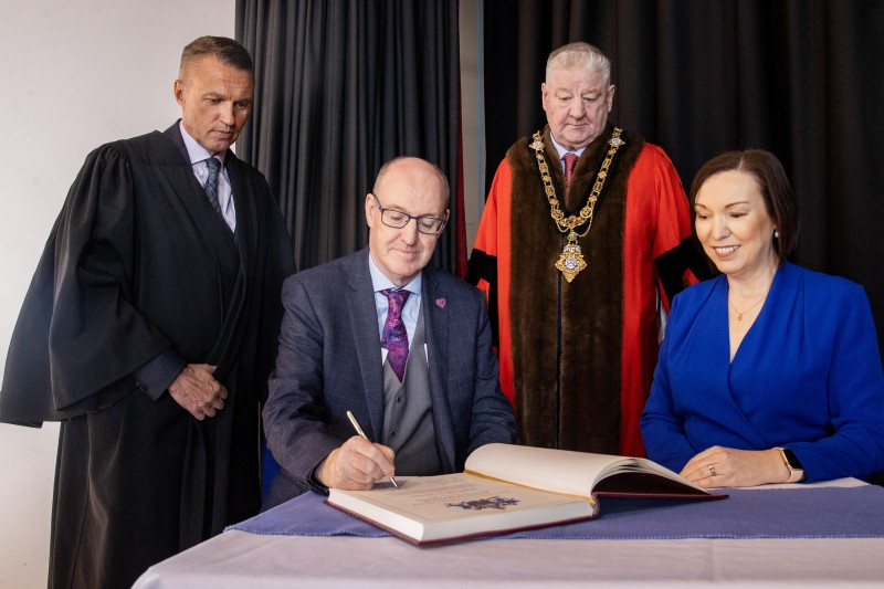 David Jackson, Chief Executive Causeway Coast and Glens Borough Council, Mayor of Causeway Coast and Glens Councillor Steven Callaghan QPM, and Jennifer Welsh, Chief Executive of the Northern Trust, as Western Trust Chief Executive Neil Guckian OBE signs the Register of Honorary Burgesses.