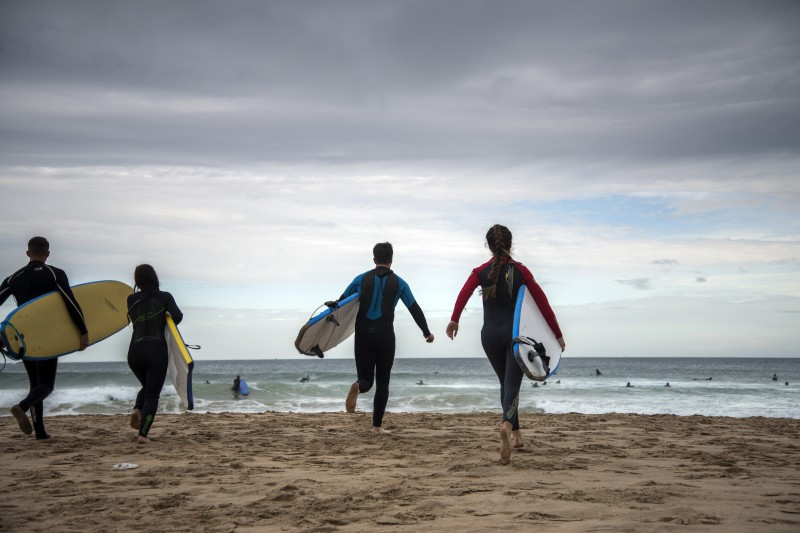 Surfers take to the water at Whiterocks, just one of the outdoor activities available for visitors to enjoy across the Causeway Coast and Glens.
