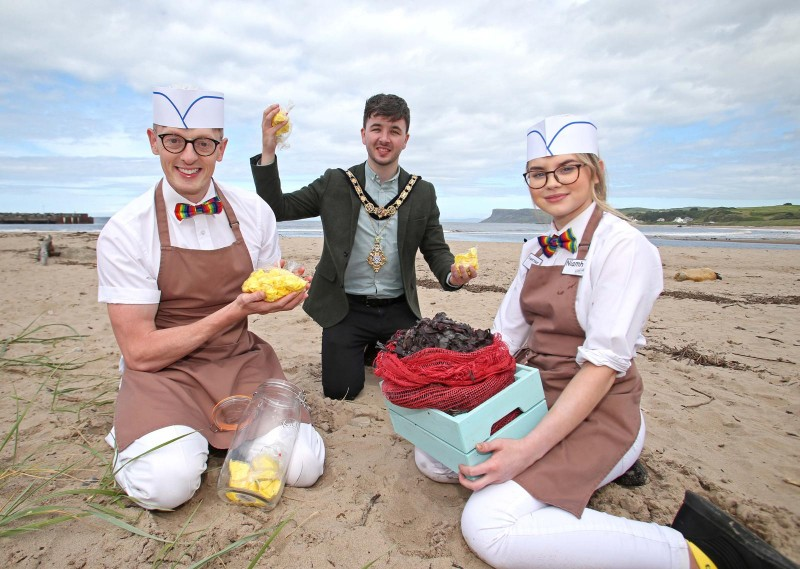 The Mayor of Causeway Coast and Glens Borough Council Councillor Sean Bateson shows off the Ould Lammas Fair’s traditional treats dulse and Yellowman alongside Keith Douthart and Niamh Gamble.
