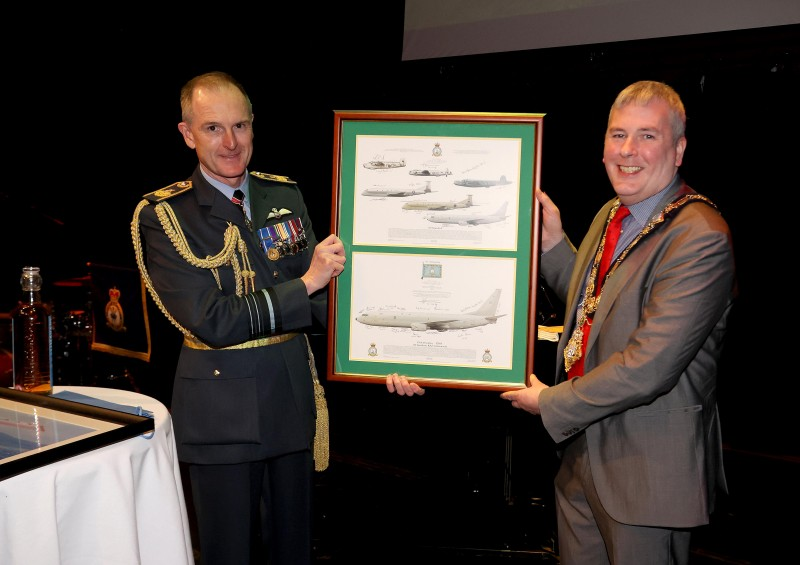 A framed selection of images showing the P8 Boeing Poseidon is presented to the Mayor by Air Marshal Sir Gerry Mayhew.