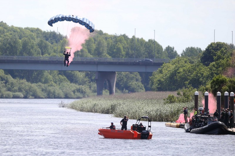 The Silver Stars parachute display team descend into the River Bann during Armed Forces Day.
