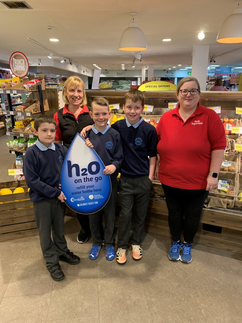 Staff from Bell’s Super-Valu pictured with pupils from Carhill Integrated Primary School after signing up to the H20 On The Go scheme.
