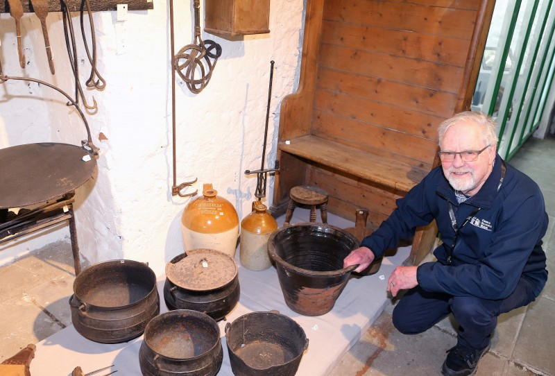 Volunteer Roger Perritt beside the museum’s mock farmhouse kitchen