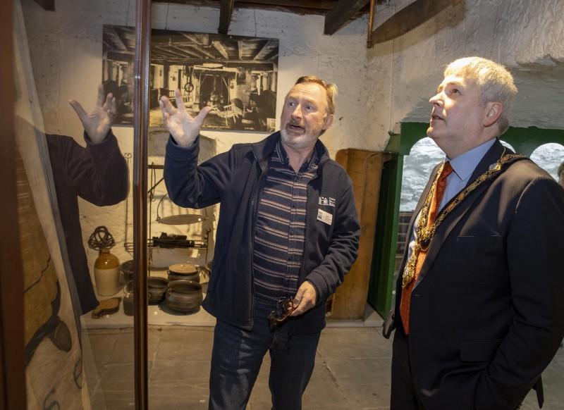 Brian Molloy, a volunteer with Friends of Ballycastle Museum, shows the Mayor of Causeway Coast and Glens Borough Council Councillor Richard Holmes some of the exhibits on display in Ballycastle Museum.