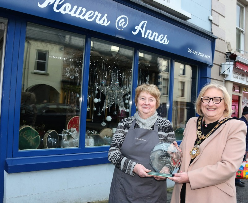 Anne Henry from Flowers @ Anne’s, winner of the Christmas window competition in Ballycastle receives her award from the Mayor of Causeway Coast and Glens Borough Council Councillor Brenda Chivers.
