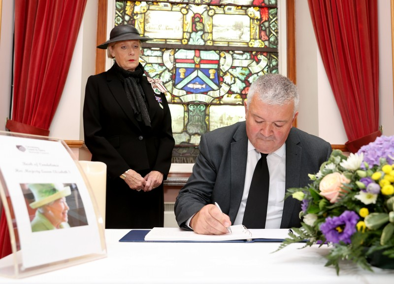 The Mayor of Causeway Coast and Glens Borough Council, Councillor Ivor Wallace, signs the book of condolence in Coleraine Town Hall, as the Lord-Lieutenant of County Londonderry, Mrs Alison Millar, looks on.