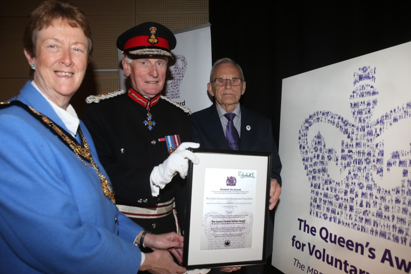 Lyle Quigley from Burnfoot Community Association displays the Queen's Award for Voluntary Service certificate with the Mayor of Causeway Coast and Glens Borough Council, Councillor Joan Baird OBE, and the Lord Lieutenant for County Londonderry, Denis Desmond CBE.