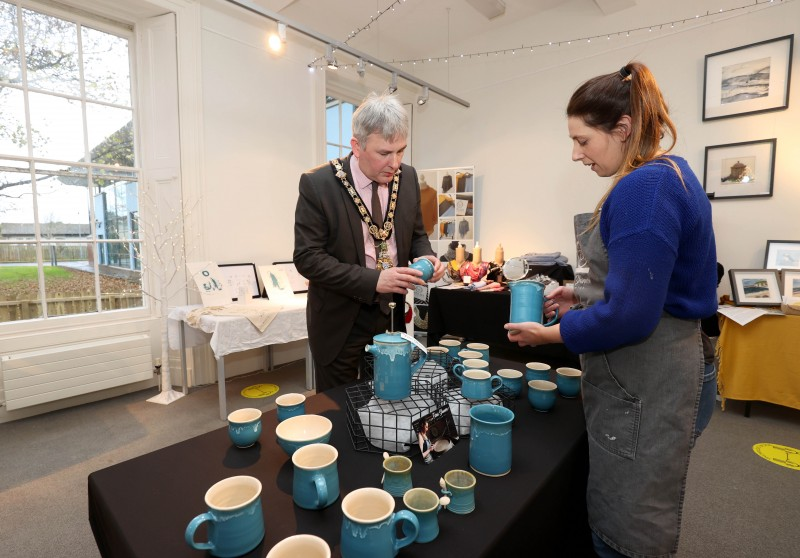 Ceramic artist Fiona Shannon shows her products to the Mayor of Causeway Coast and Glens Borough Council, Councillor Richard Holmes at Flowerfield Arts Centre’s popular Christmas Craft Market.