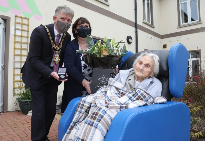 Sarah Wilson receives her NI 100 commemorative coin to mark her 100th birthday from the Mayor of Causeway Coast and Glens Borough Council Alderman Mark Fielding and Mayoress Mrs Phyllis Fielding.