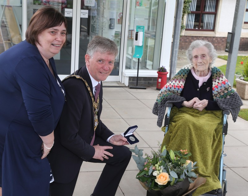 Christina McMullan, who celebrated her 100th birthday on January 23rd, receives her NI 100 commemorative coin from the Mayor of Causeway Coast and Glens Borough Council Alderman Mark Fielding and Mayoress Mrs Phyllis Fielding.