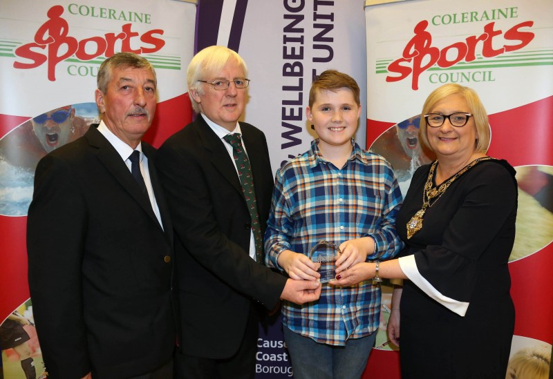 Young swimmer Tyler Troy, winner of Sportsperson with a Disability, receives his award from the Mayor of Causeway Coast and Glens Borough Council Councillor Brenda Chivers with John Church, Chair Coleraine Sports Council and Robert McVeigh from Northern Ireland Commonwealth Games Council. Tyler won three gold medals at the Special Olympics Regional Finals in Dublin.