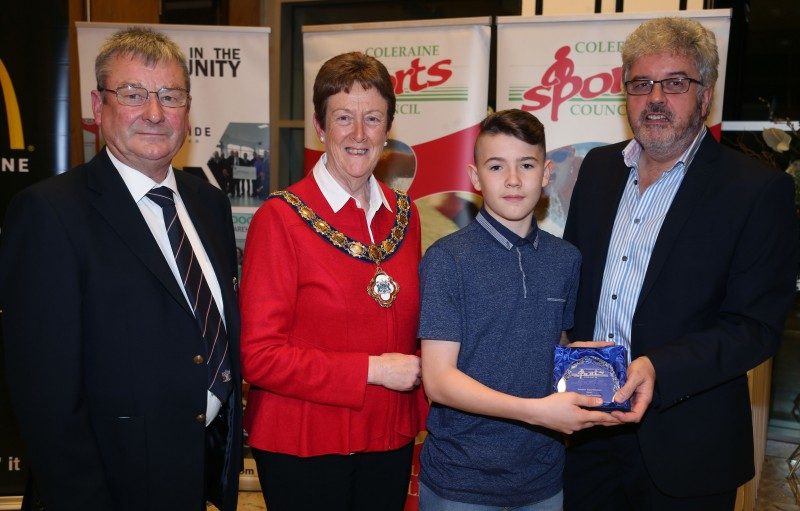 Dylan McCloskey, a member of Zanghin Shotokan Karate Club, winner of the Junior Sportsman award, receives his award from the Mayor of Causeway Coast and Glens Borough Council Councillor Joan Baird OBE, Grant Cameron, BBC Sport Northern Ireland and Hugh Wade, Chairman of Coleraine Sports Council.