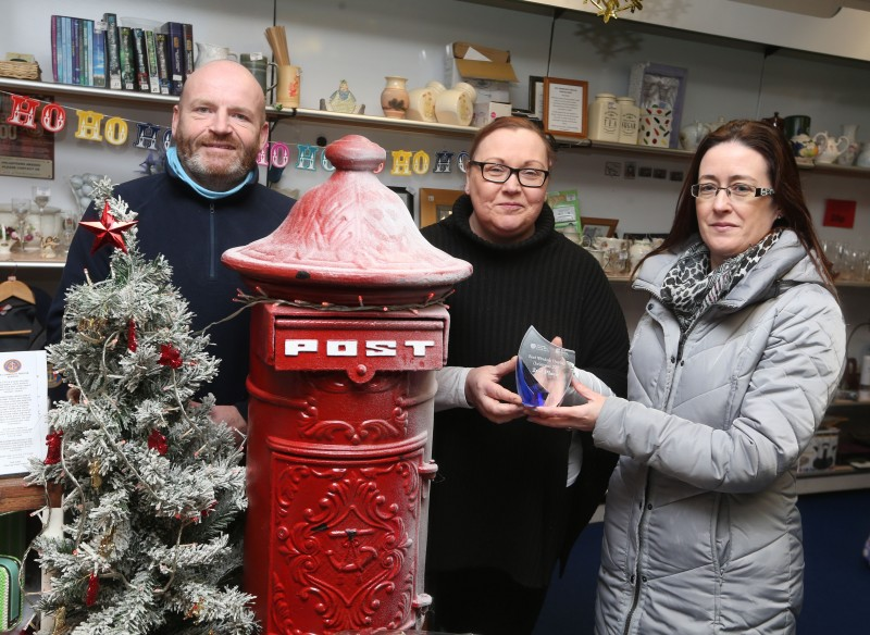 Hazel Gallagher &Alistair Warke representing the Community Rescue Service shop receive their prize for taking second place in the Christmas Window Competition in Coleraine from Causeway Coast and Glens Borough Council Officer Catrina McNeill.