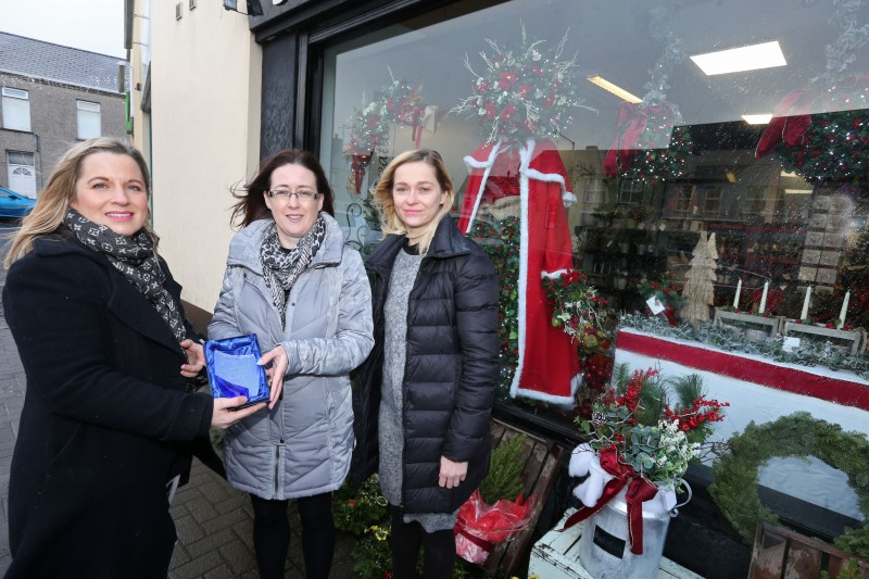 Jayne Morris and her shop assistant Kasia receives their prize for coming third in the Christmas Window Competition from Causeway Coast and Glens Borough Council Officer Catrina McNeill.
