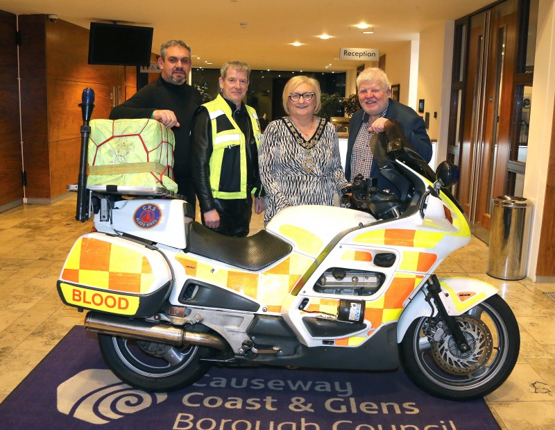 The Mayor of Causeway Coast and Glens Borough Council, Councillor Brenda Chivers is shown a CRS Blood Bike by Sean Mc Carry, Alan Hamilton and David Buchanan.