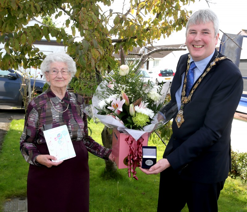 The Mayor of Causeway Coast and Glens Borough Council Councillor Richard Holmes presents a centenary coin to Dorothy Cunningham to mark her 100th birthday which takes place on Saturday 25th September 2021.