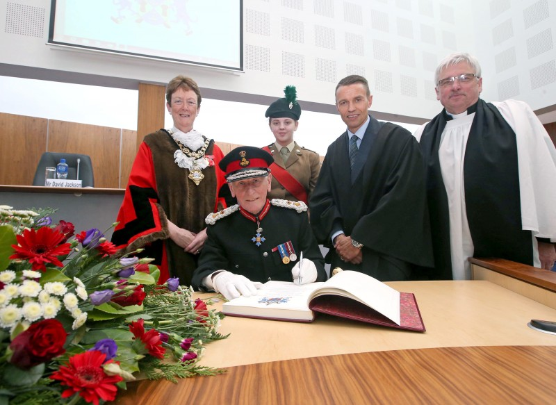 Sir Denis Desmond KCVO CBE, Lord Lieutenant of County Londonderry signs the Freedom register as he becomes a Freeman of the Borough of Causeway Coast and Glens from the Mayor Councillor Joan Baird OBE, Council Chief Executive David Jackson, the Mayor’s Chaplain Reverend David Ferguson and cadet Alicia Campbell during the Freedom of the Borough ceremony