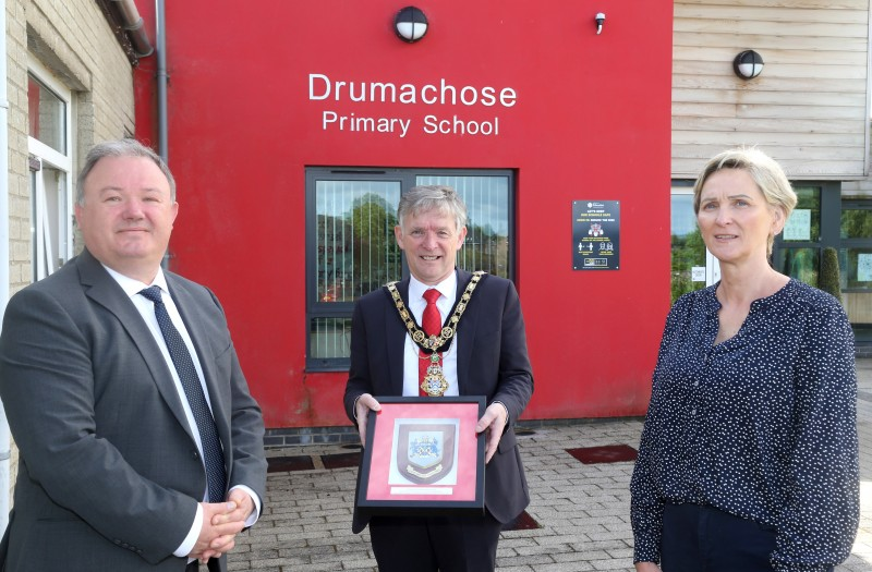 The Mayor of Causeway Coast and Glens Borough Council Alderman Mark Fielding presents a framed coat of arms to Drumachose Primary School principal Marshall Gilgore and Pamela McLean, Chair of the Board of Governors.
