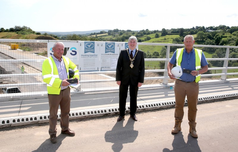 The Mayor of Causeway Coast and Glens Borough Council Councillor Richard Holmes presented a token of gratitude to Tony Lowe (left) and Darren McClane from Wills Bros Ltd, part of the contractor consortium carrying out the A6 road scheme at Dungiven