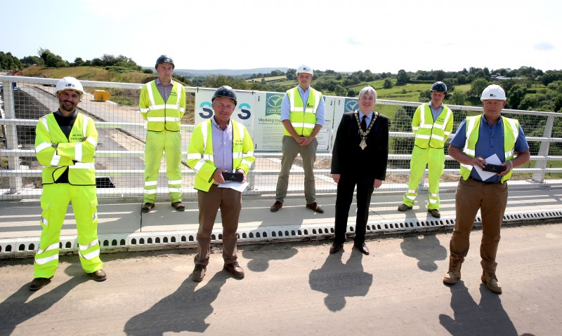 The Mayor of Causeway Coast and Glens Borough Council Councillor Richard Holmes pictured with representatives of the management team carrying out the A6 road scheme in Dungiven.