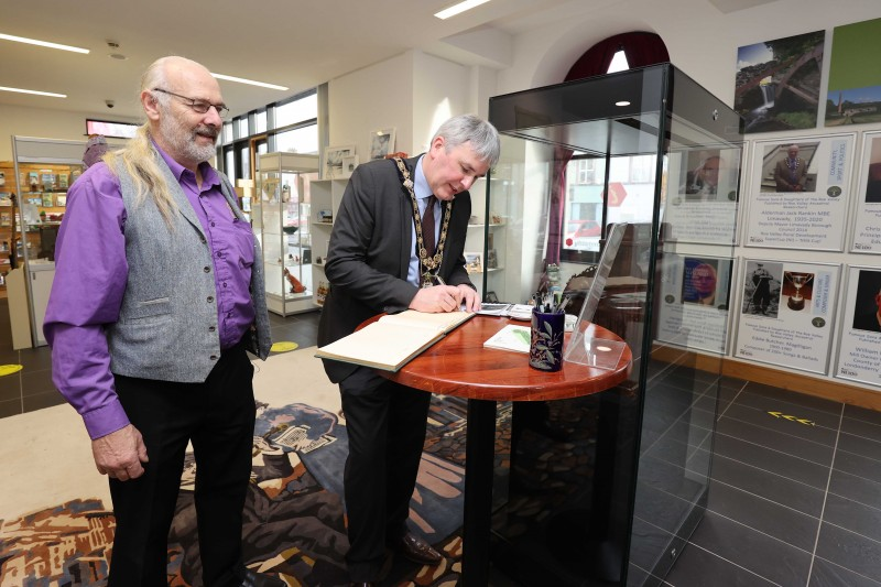 The Mayor of Causeway Coast and Glens Borough Council, Councillor Richard Holmes signs the visitors’ book at the opening of the NI100 - Influencers from the Roe Valley’ Exhibition with Matthew Ferguson from Roe Valley Ancestral Researchers.