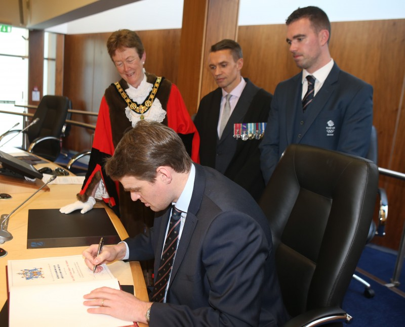 Alan Campbell signs the Freedom Register as the Mayor, Councillor Joan Baird OBE, Chief Executive David Jackson and Richard Chambers look on.
