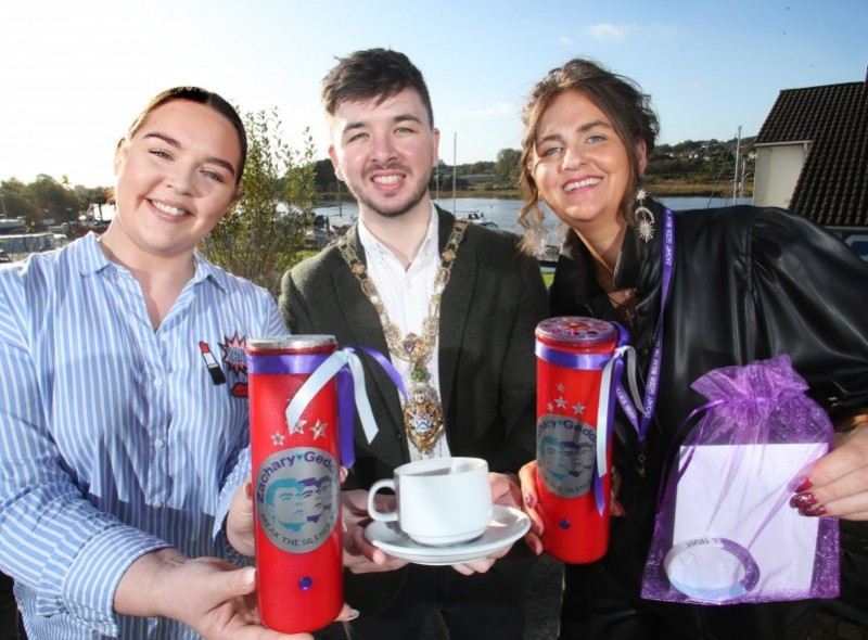 Yasmin and Louise Geddis show off The Trust’s #KeepTheLightOn campaign candles alongside the Mayor of Causeway Coast and Glens Borough Council Councillor Sean Bateson.