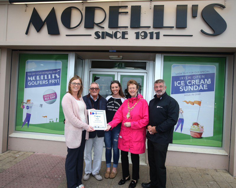 Nino and Francesca Morelli receive their prize after Morelli's was selected in third place in the window dressing competition as part of the build up to the Dubai Duty Free Irish Open from Annette Deighan from Causeway Chamber of Commerce, the Mayor of Causeway Coast and Glens Borough Council Councillor Joan Baird and Eddie Rowan from Tourism NI.