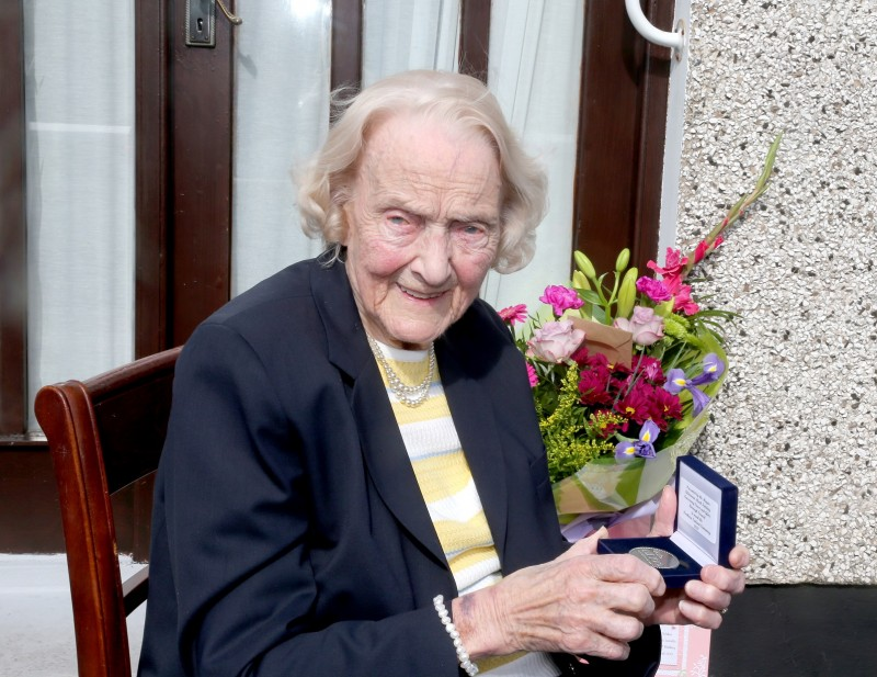 100-year-old Isabelle Claypole displays her commemorative centenary coin received from the Mayor of Causeway Coast and Glens Borough Council Alderman Mark Fielding.