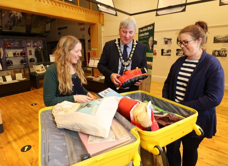 Museum Officers Jamie Austin and Sarah Calvin show the new ‘Loan Box’ of materials for use by nurseries, schools, or community groups to the Mayor of Causeway Coast and Glens Borough Council, Councillor Richard Holmes