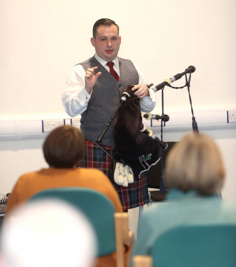 Piper Darren Milligan speaks to the audience during the musical evening held at Magilligan Community Centre.