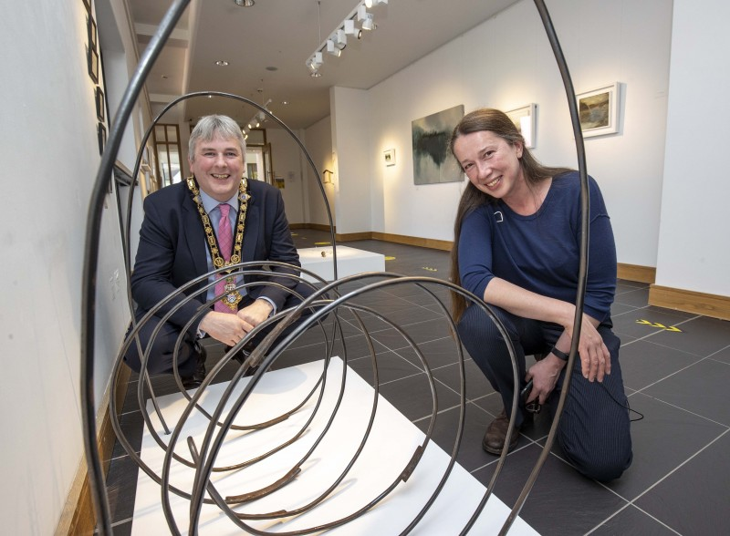 Sharon Adams shows one of her metal works, inspired by old hay-shaking techniques, to the Mayor of Causeway Coast and Glens Borough Council Councillor Richard Holmes during his visit to the Beyond Edges exhibition at Roe Valley Arts and Cultural Centre.