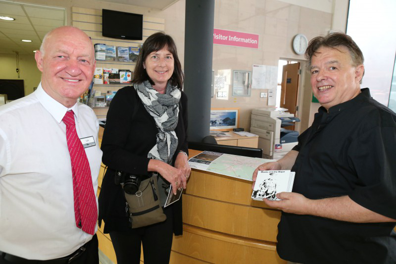 David Kane, CD producer is pictured with Visitor Information Staff member Lyle McMullan and Cheryl Papove a tourist from Canada.