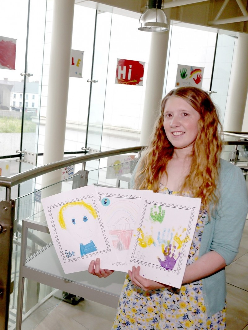Museums Officer Jamie Austin with artwork created by the children as part of ‘From me to you- A journey of a postcard’.