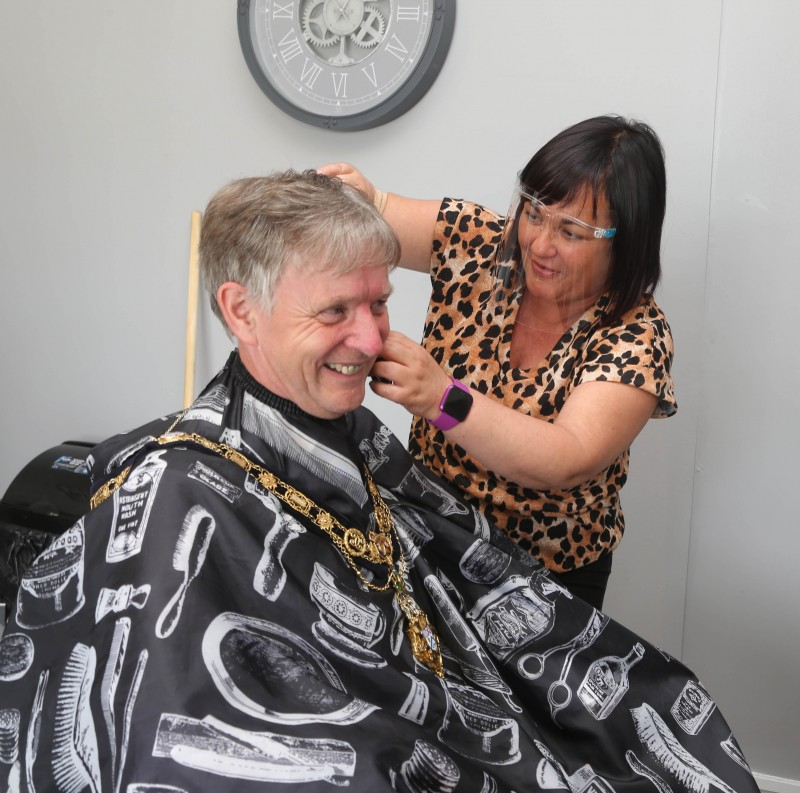 Kerry Macauley, proprietor of Buzz Cutz which has relocated to Millburn Community Association’s premises, give the Mayor, Alderman Mark Fielding, a hair cur during his visit.