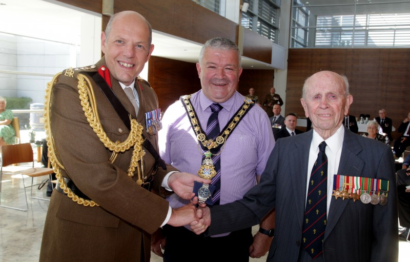 Corps Colonel, Colonel IJ Philips, presents a special gift to Norman Irwin, along with the Mayor of Causeway Coast and Glens Borough Council Councillor Ivor Wallace.