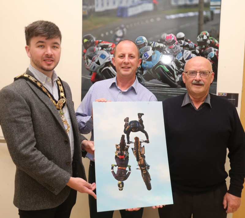 Wilbert McIllmoyle, one of the People’s Choice winners in this year’s ‘Capture the Moment’ International NW 200 photography competition pictured with The Mayor of the Causeway Coast and Glens Borough Council, Councillor Sean Bateson and Fergus Mackay, Event Operations Manager of the NW200.