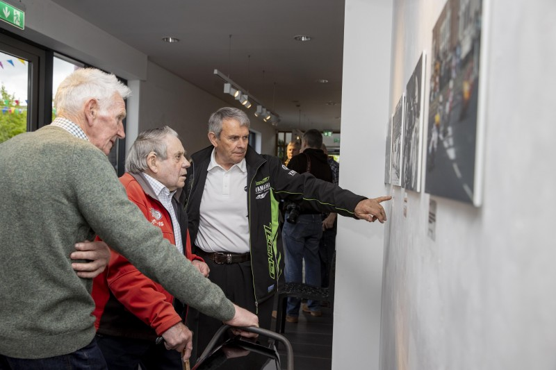 Famous past NW200 racers, two-time winner Dick Creith (left) and Len Ireland (centre), reflect over the new photographic exhibition at Roe Valley Arts and Cultural Centre, which features historic images taken from the book the ‘NW200 90th Road & Race’, by Ian Foster.