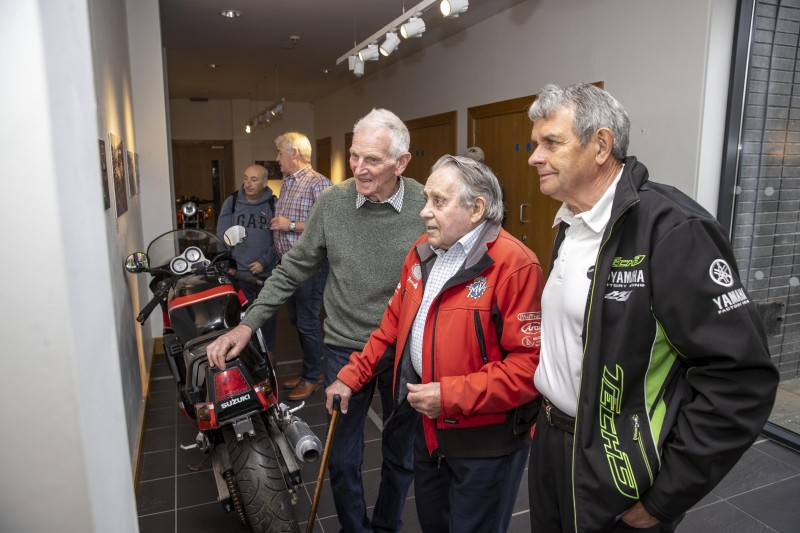 Famous past NW200 racers, two-time winner Dick Creith (left) and Len Ireland (centre), reflect over the new photographic exhibition at Roe Valley Arts and Cultural Centre, which features historic images taken from the book the ‘NW200 90th Road & Race’, by Ian Foster.