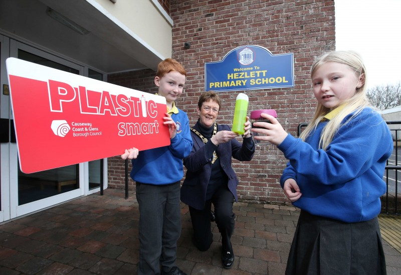 The Mayor of Causeway Coast and Glens Borough Council Councillor Joan Baird OBE helps Ross and Brooke from Hezlett Primary School celebrate their position as the first 'Plastic Smart' school in the Causeway Coast and Glens.
