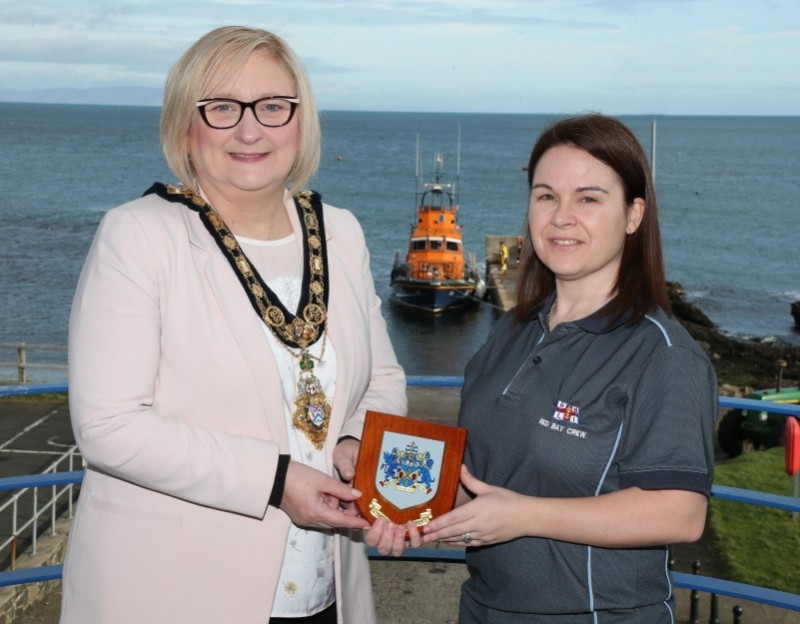 Crew member Sinead Sharpe receives a Coat of Arms from the Mayor of Causeway Coast and Glens Borough Council Councillor Brenda Chivers.