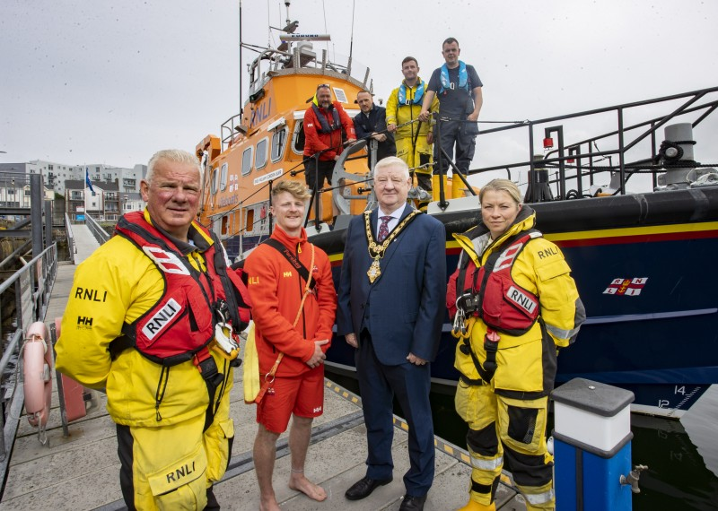 Mayor of Causeway Coast and Glens, Councillor Steven Callaghan launches the official charity partnership with RNLI. He is pictured with Portrush RNLI Coxswain Des Austin, RNLI Lifeguard James Wright, RNLI Portrush crew member Deborah Smyth and other crew members.