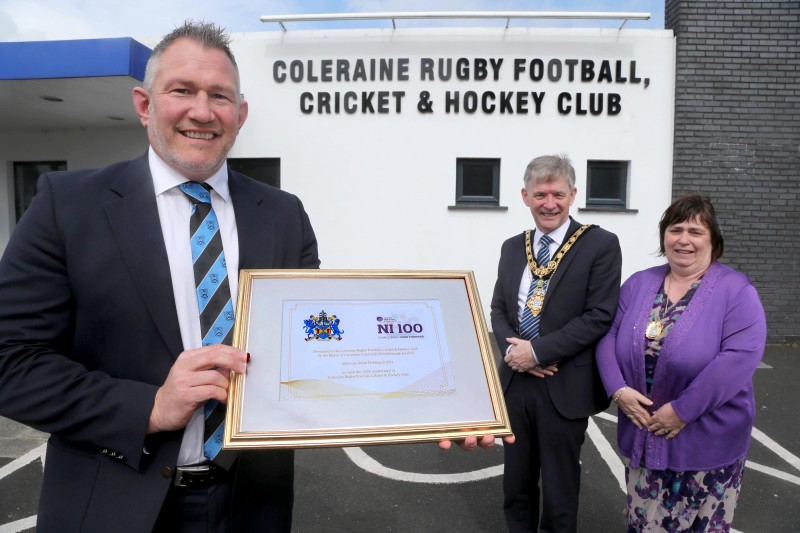 The Mayor of Causeway Coast and Glens Borough Council Alderman Mark Fielding and Mayoress Mrs Phyliss Fielding present a framed certificate to Andrew Hutchinson, President of Coleraine Rugby Football, Cricket and Hockey Club, to mark the club’s centenary