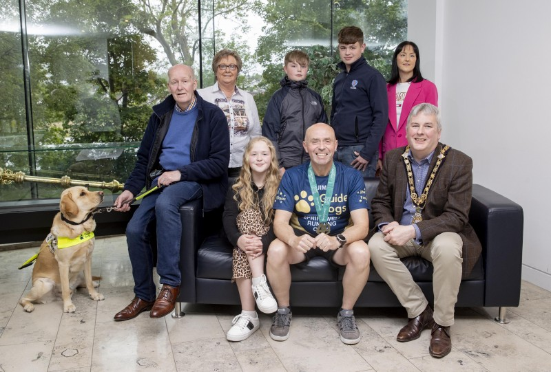The Mayor of Causeway Coast and Glens Borough Council, Councillor Richard Holmes (front-right), recently held a special reception for local athlete, Jim Bradley (front-centre). They were joined by Jim’s close friend Iain Matthew (front-left), Iain’s family and his guide dog Mac. Jim is currently raising much needed funds for Guide Dogs NI by running a series of marathons.