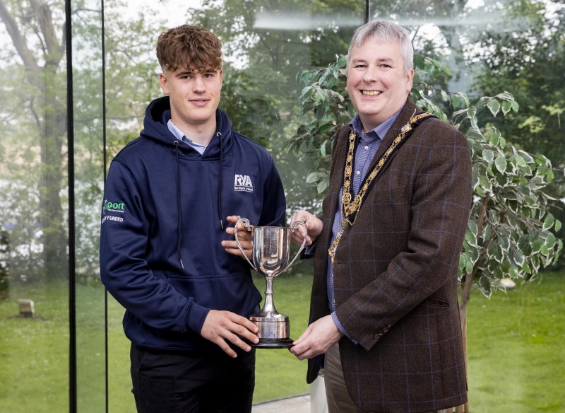 Tom Coulter (left) displays the Bain Dickinson trophy (awarded for his achievement in youth sailing) at a recent reception held in his honour by the Mayor of Causeway Coast and Glens Borough Council, Councillor Richard Holmes.