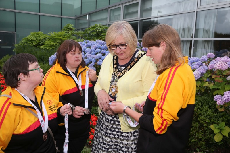 Alison Grant, Catherine Parke and Joanne Kerr from Causeway Coast Special Olympics Club show their medals to the Mayor of Causeway Coast and Glens Borough Council Councillor Brenda Chivers.