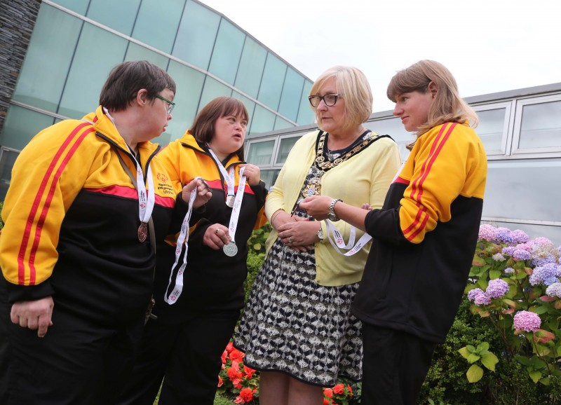 Alison Grant, Catherine Parke and Joanne Kerr from Causeway Coast Special Olympics Club show their winning medals to the Mayor of Causeway Coast and Glens Borough Council Councillor Brenda Chivers.