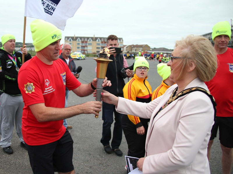 The Mayor of Causeway Coast and Glens Borough Council Councillor Brenda Chivers receives the Flame of Hope during the Law Enforcement Torch Run visit to Portrush.