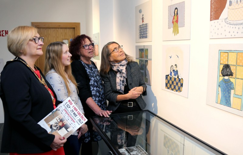 The Mayor of Causeway Coast and Glens Borough Council Councillor Brenda Chivers views the War-Torn Children exhibition with curator Roberta Bacic and Helen Perry and Jamie Austin from Council's Museums Service.